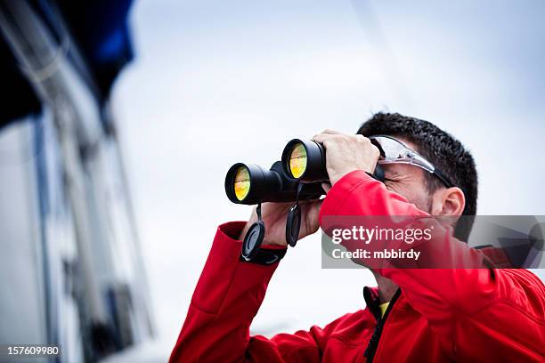 sailor with binoculars on sailboat - sailing navigation stock pictures, royalty-free photos & images