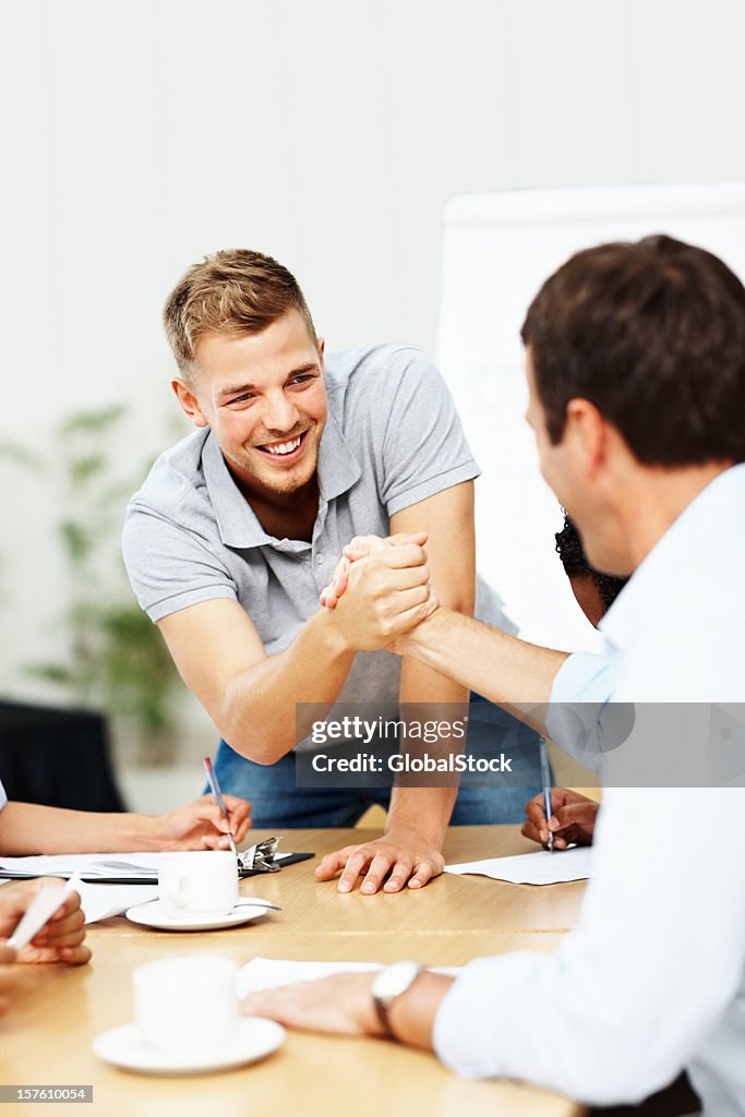 Happy business man shaking hands with colleague at a meeting
