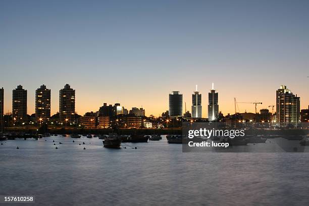 montevideo cityscape at dusk from a marina - montevideo stock pictures, royalty-free photos & images