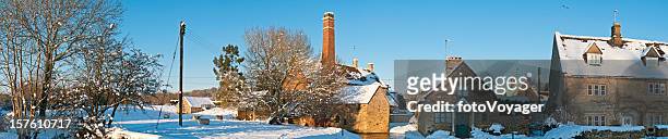 idyllic winter village cottages watermill crisp white snow cotswolds uk - waterrad stockfoto's en -beelden