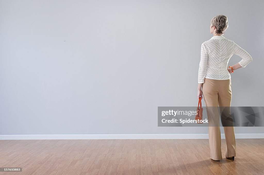 Stylish Woman Looking At Blank Wall