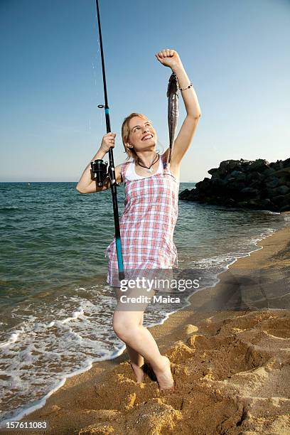 fishing girl with her catch at the beach - hake stock pictures, royalty-free photos & images