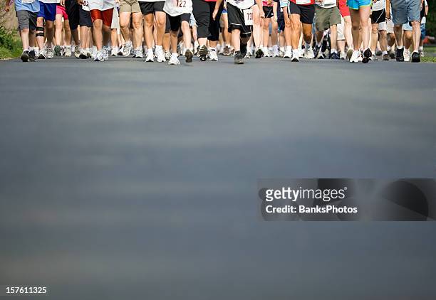 walker’s legs with pavement foreground - fun run stock pictures, royalty-free photos & images