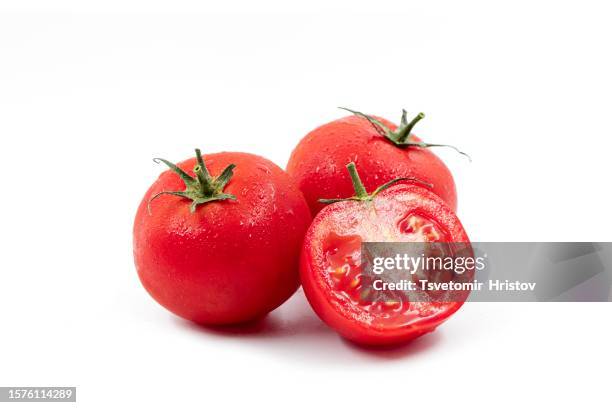 tomatoes. whole and a half isolated on white - tomate fotografías e imágenes de stock