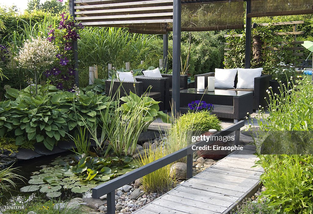 Moderner Außenpatio Garten mit einem Teich und lounge im Freien mit Couch