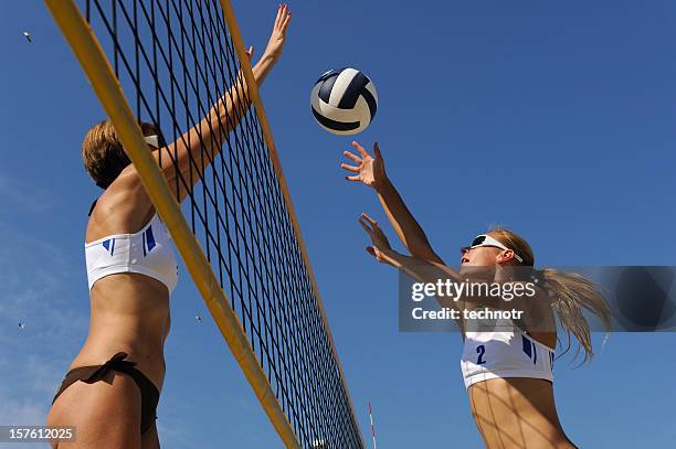 voleibol playero acción in mid-air - juego de voleibol de playa fotografías e imágenes de stock