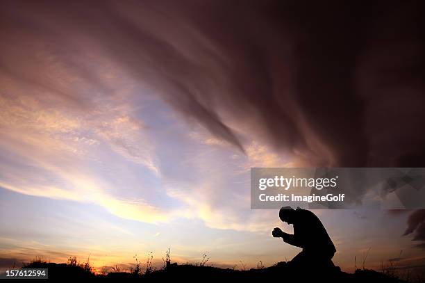 silhouette di irriconoscibile caucasica uomo di pregare durante la tempesta - religione foto e immagini stock