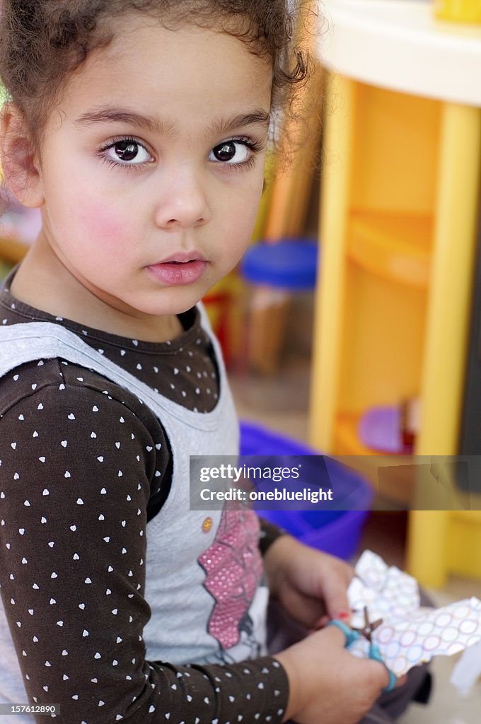 Three Years Old Girl Cutting Paper Using Scissors