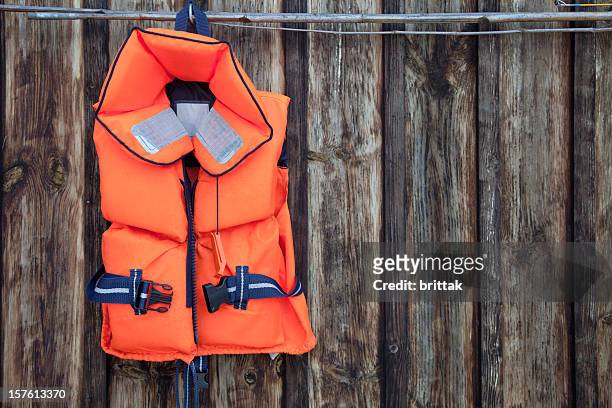 life jacket for a child against an old wooden wall. - flytväst bildbanksfoton och bilder