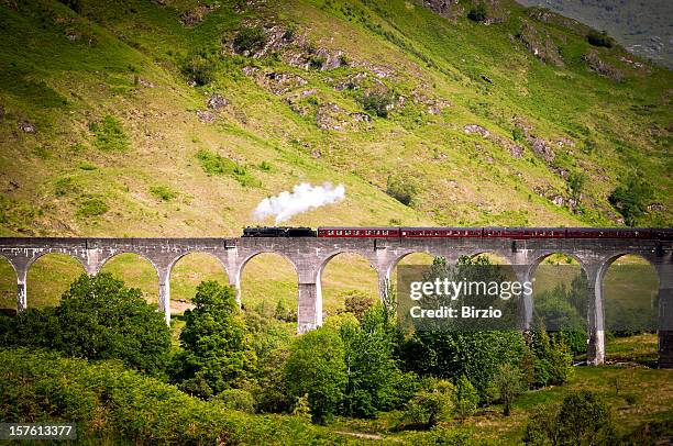 antique steam train running on a viaduct - glenfinnan stock pictures, royalty-free photos & images