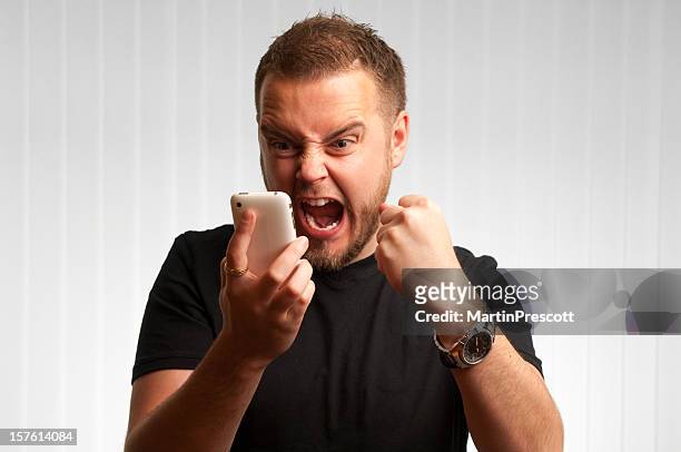 young male screams at phone - exhilaration stock pictures, royalty-free photos & images