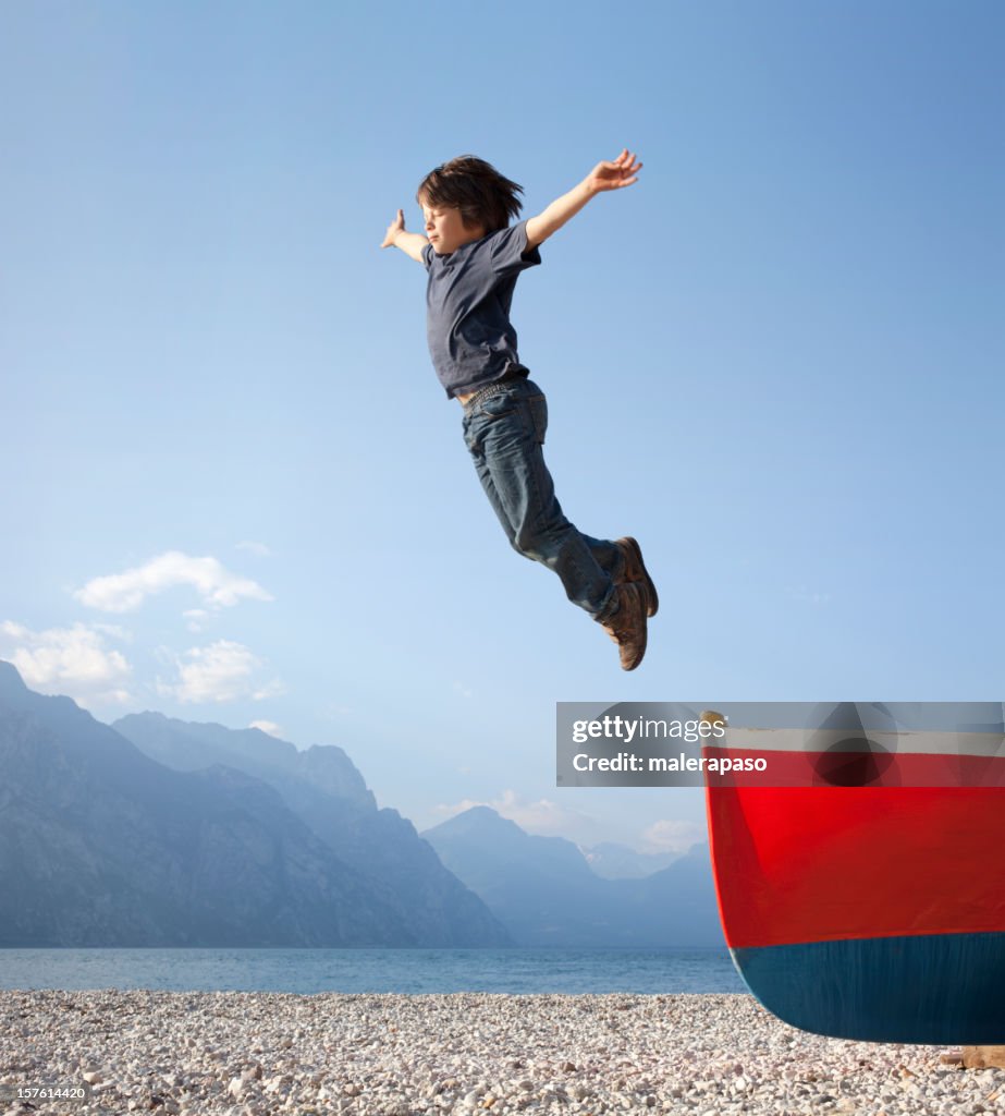 Boy jumps from a boat