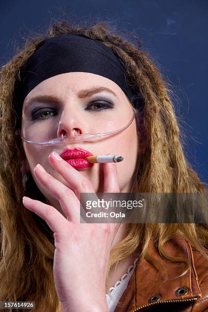 woman on medical oxygen smoking a cigarette - breathing device stock pictures, royalty-free photos & images