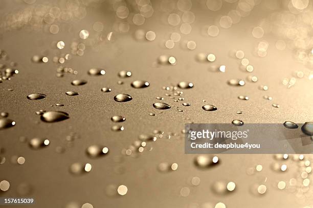 water drops on a polished gold metalic motorhood - gold foil texture stockfoto's en -beelden
