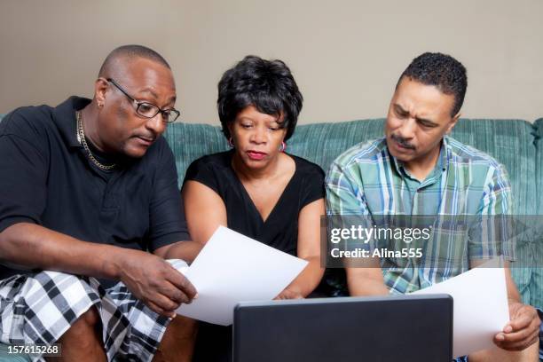 african-american family looking at the papers in their home - stern form stock pictures, royalty-free photos & images