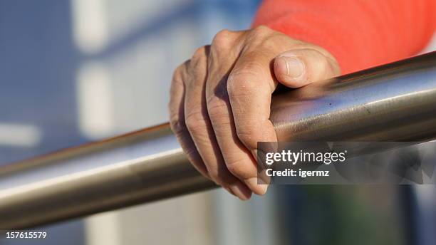 senior hand grasps stainless steel railing - railings stock pictures, royalty-free photos & images