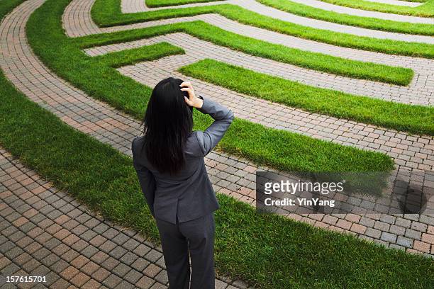 maze with lost business woman facing employment and occupation issues - career path stock pictures, royalty-free photos & images