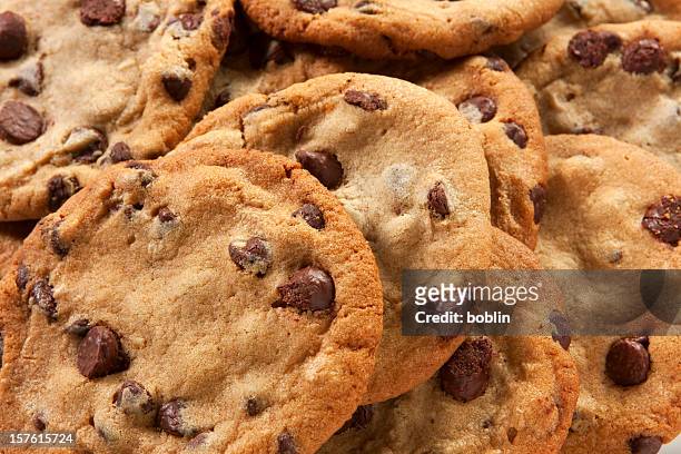 slightly overdone chocolate chip cookies in a messy pile - cookie stock pictures, royalty-free photos & images