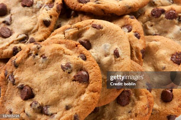 slightly overdone chocolate chip cookies in a messy pile - chocolate chip cookie stock pictures, royalty-free photos & images