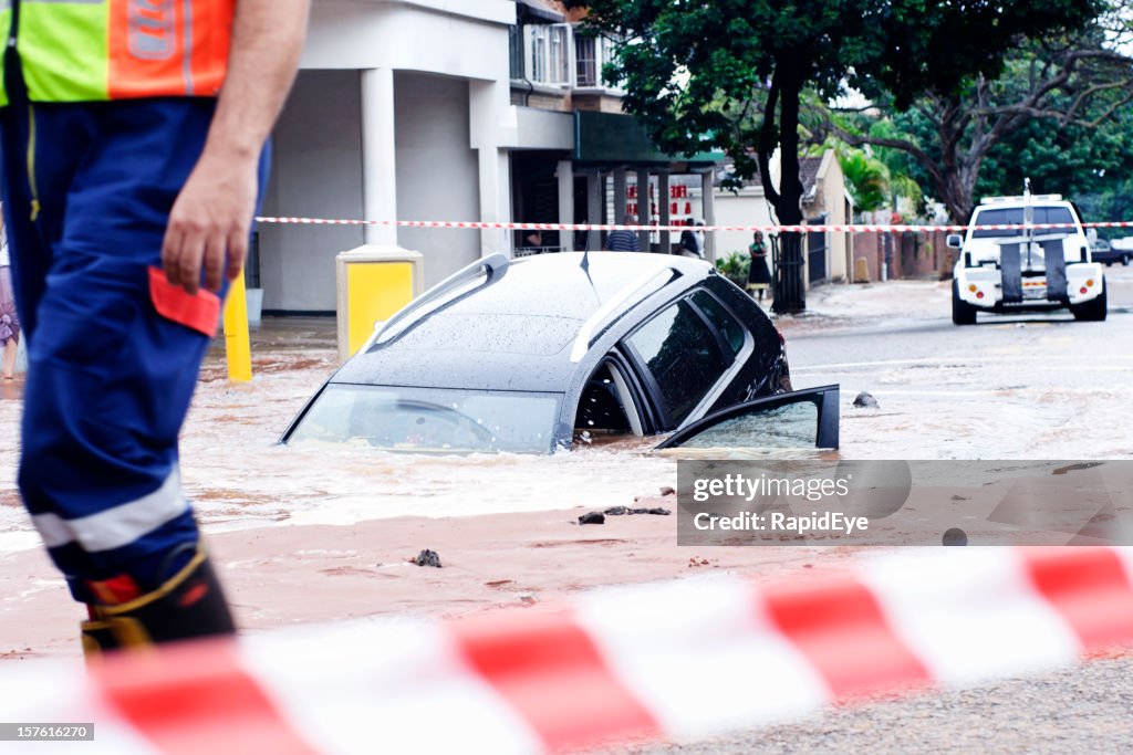 Oops! Car slipping into pothole in flooded street