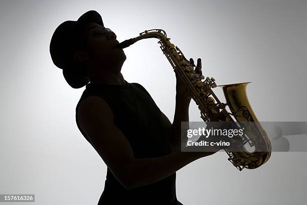 silhouette of a man playing the saxophone - saxophonist stock pictures, royalty-free photos & images