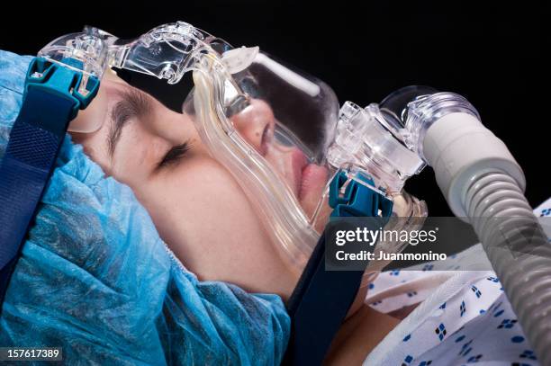 child sleeping using a breathing device - bewusteloos stockfoto's en -beelden