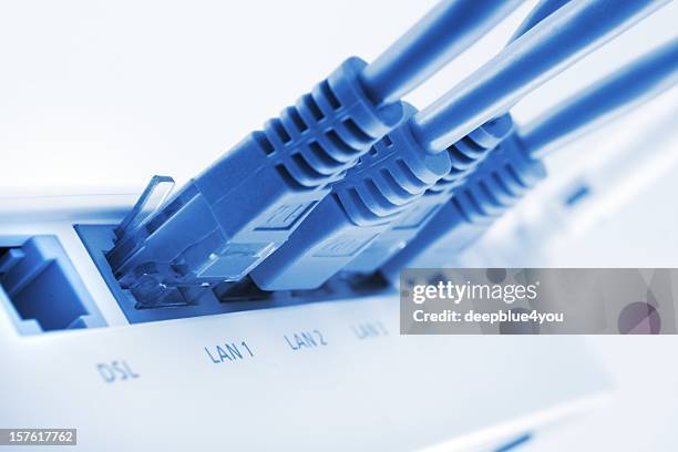 pluged in lan cables - internet router stock pictures, royalty-free photos & images