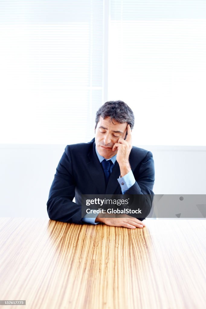 Mid adult businessman taking a nap in office