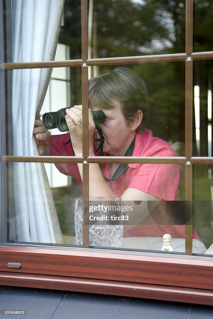 Neugierig Nachbarn am Fenster mit Fernglas