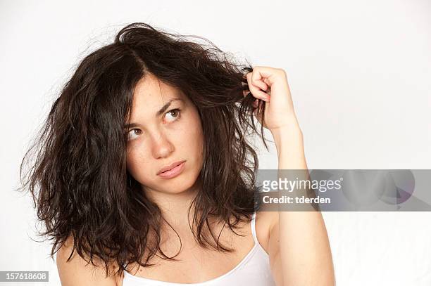 woman clutching wavy dark hair over a white background - human hair stockfoto's en -beelden