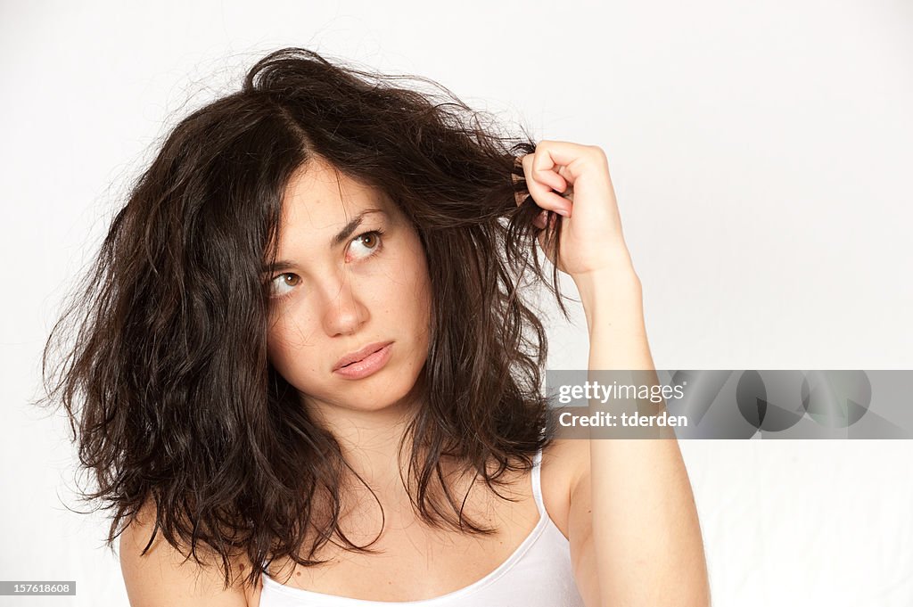 Woman clutching wavy dark hair over a white background