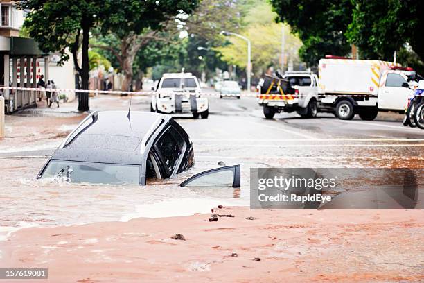 car sinks into pothole in flooded urban road - slukhål bildbanksfoton och bilder