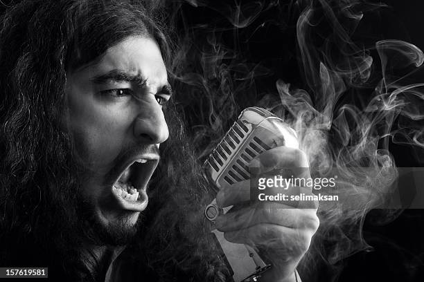 seventies rock star singing on old fashioned microphone in smoke - heavy metal stock pictures, royalty-free photos & images