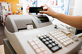 Woman's hand checks readout on cash register