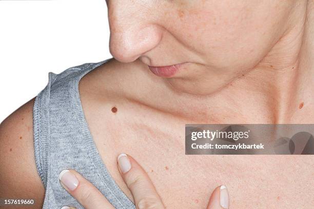 woman self-examining skin for potential cancerous growths - melanoma stock pictures, royalty-free photos & images