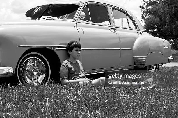 portrait of a boy laying on the car in black & white picture - 1950 1959 stock pictures, royalty-free photos & images