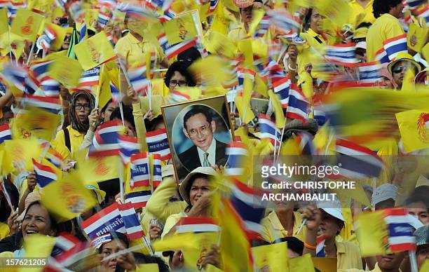 Portrait of Thai King Bhumibol Adulyadej is held up by one of tens of thousands of Thais gathered outside the Anantasamakom Throne Hall as they wait...