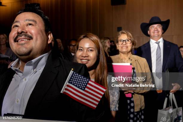 New immigrants, Miguel Enriquez, Linda Phan, Rocio Enriquez and Charles Heckroodt smile after they officially became US citizens at a naturalization...