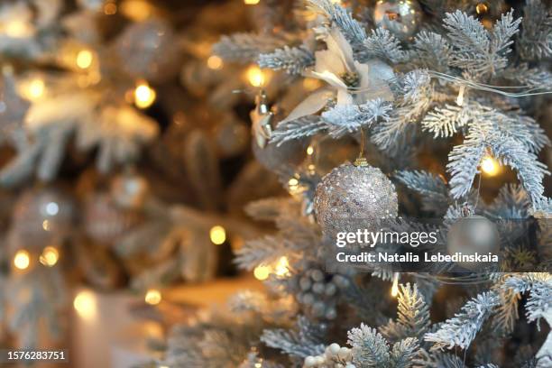 festive winter glow: close-up of christmas tree decoration with soft-focus, blurry lights. silver and gold elegance for joyous celebrations. copy space - softfocus stock pictures, royalty-free photos & images