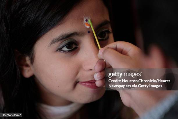 Jashma Kheral sits as his brother Umesh Kheral applies the Tika, seven colors, on her forehead during the Bhai Tika as they celebrate Deepawali in...