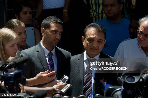 Vinod Hindocha father of murdered tourist, Anni Dewani, flanked by his son Anish, answers to journalists outside the High Court of Cape Town on...