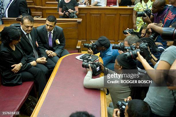 Vinod Hindocha father of murdered tourist, Anni Dewani, flanked by his son Anish and by police officer Louise Smit are pictured by photographers in...