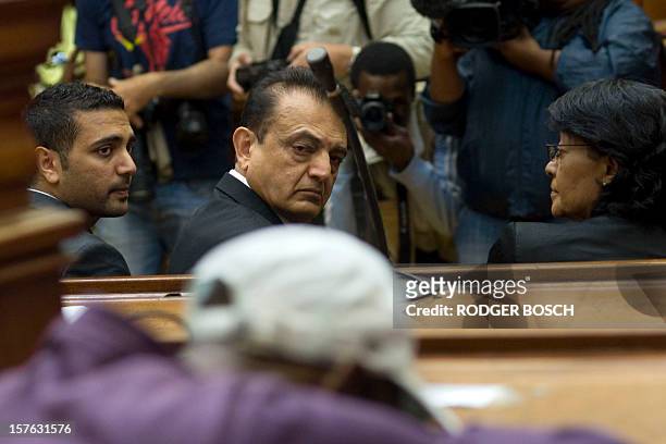 Vinod Hindocha father of murdered tourist, Anni Dewani, flanked by his son Anish looks at Xolile Mngeni , the man convicted of firing the bullet that...