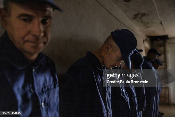 Russian POWs are seen waiting in line to call home to Russia in a prisoner of war detention camp on August 3, 2023 in the Lviv region, Ukraine....