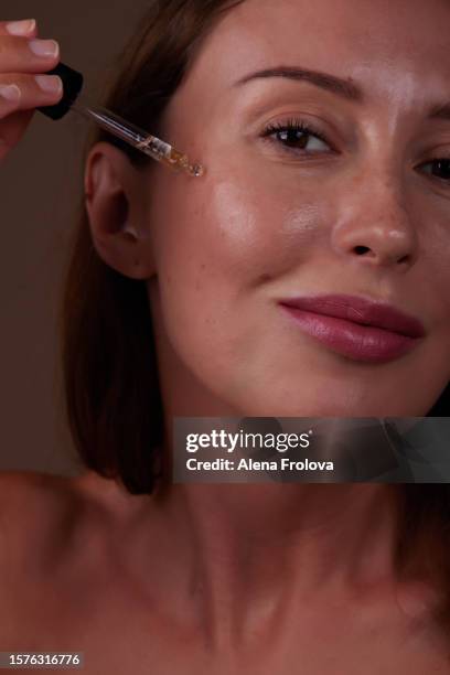 beautiful woman getting skin anti aging treatment - sérum visage photos et images de collection