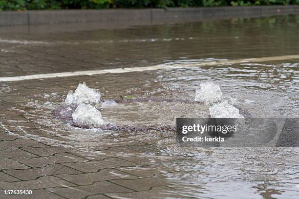 flooded manhole cover - storm drain stock pictures, royalty-free photos & images