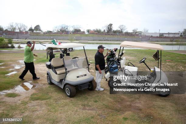 Guillermo "Wicho" Flores, of Piedras Negras, and Roberto Gonzalez, of Eagle Pass, move on to the next hole as they play golf at the Eagle Pass Golf...