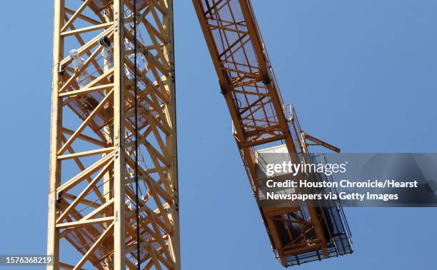 Technician Eric Brannam, and Claude Griffin, owner of Gotcha Pest Control, remove bees from crane at a high rise under construction site along 5300...