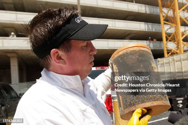 Claude Griffin, owner of Gotcha Pest Control, carries several thousands of bees removed from a high rise under construction along 5300 block of...
