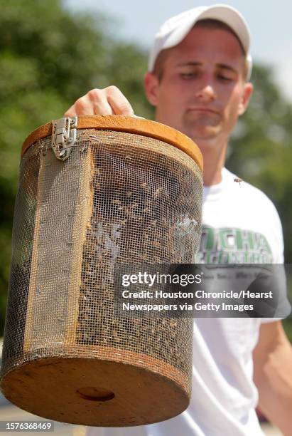 Eric Brannam, a Gotcha Pest Control Technician, carries several thousands of bees removed from a high rise under construction along 5300 block of...